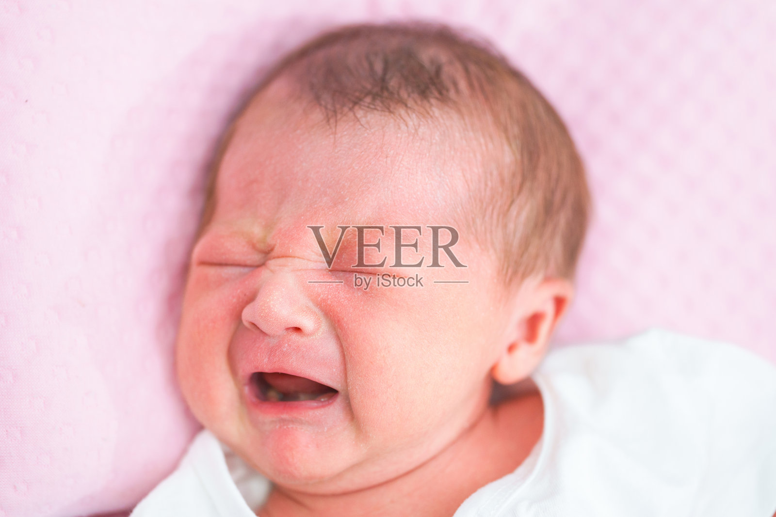 一个刚出生的亚洲女婴的肖像睡在床上,可爱的胖娃5天。照片摄影图片