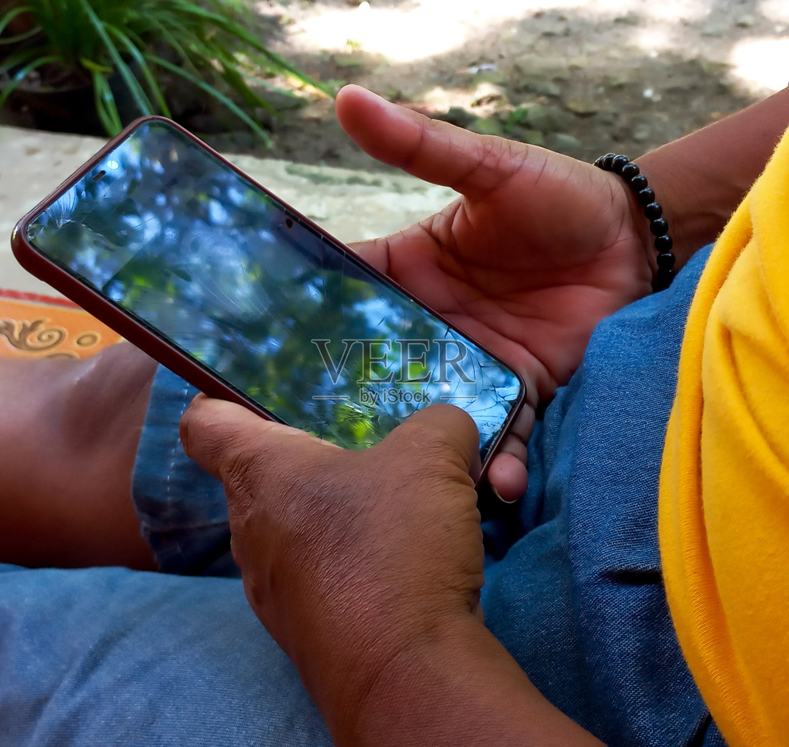 一个棕色皮肤的亚洲女人的手拿着智能手机的特写照片摄影图片