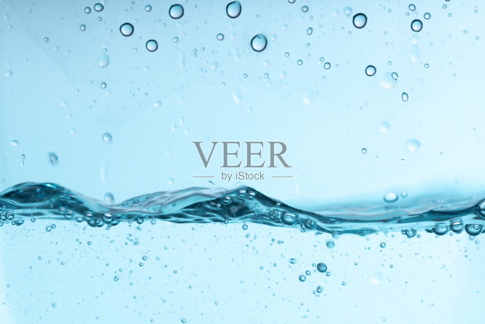 蓝色的水花溅在玻璃器皿里。干净的清水照片摄影图片