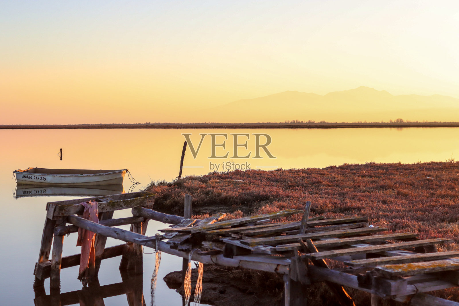 从海边废弃的木码头眺望渔船照片摄影图片