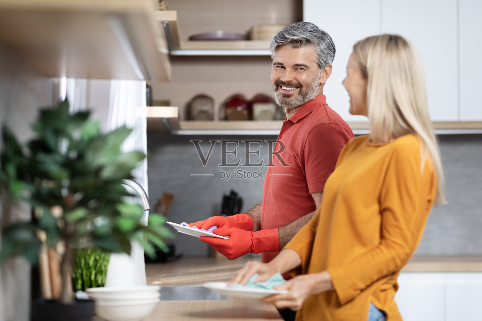 英俊的中年丈夫帮助妻子做家务,洗碗照片摄影图片