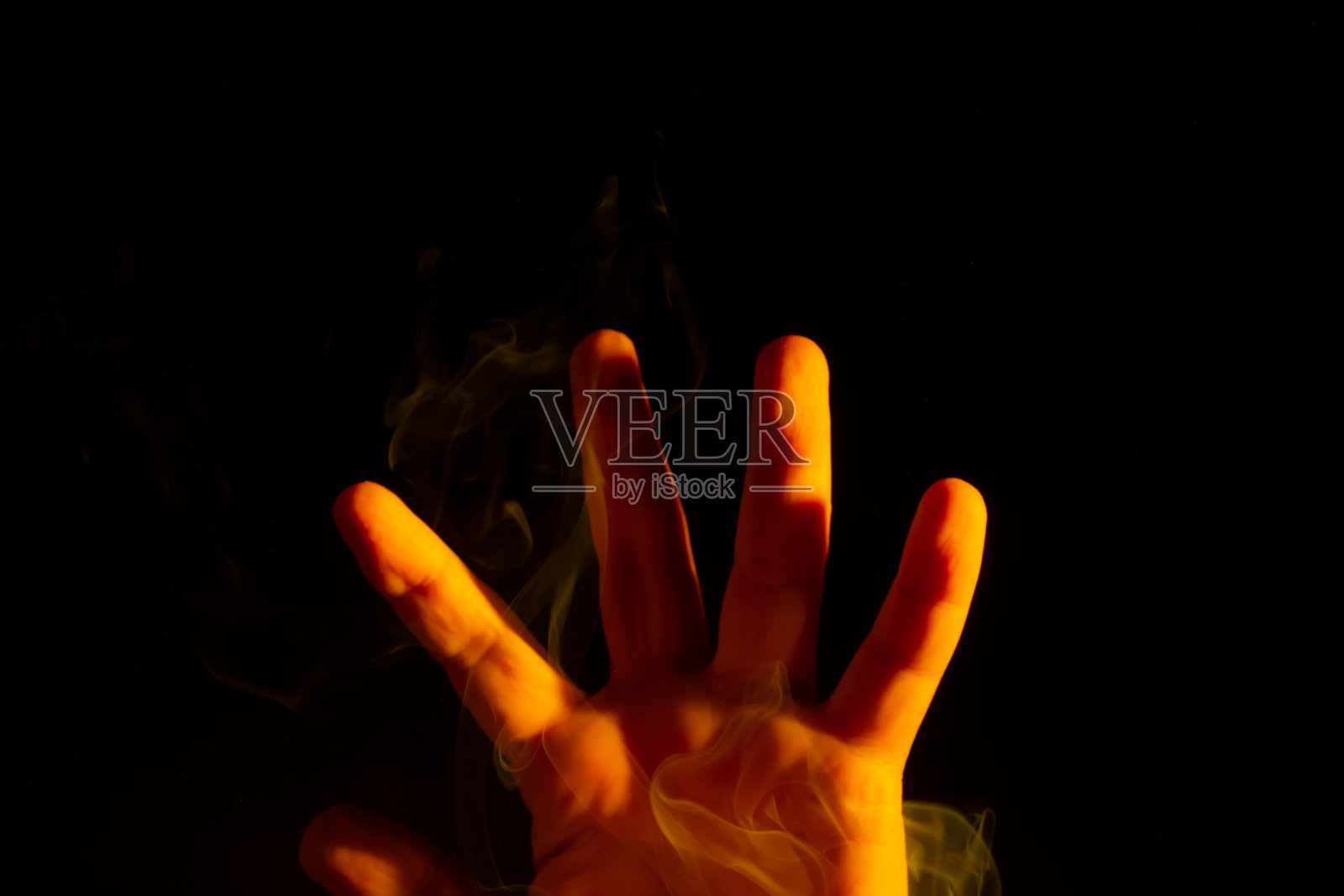 一只男性的手被周围的烟熏得发黄照片摄影图片