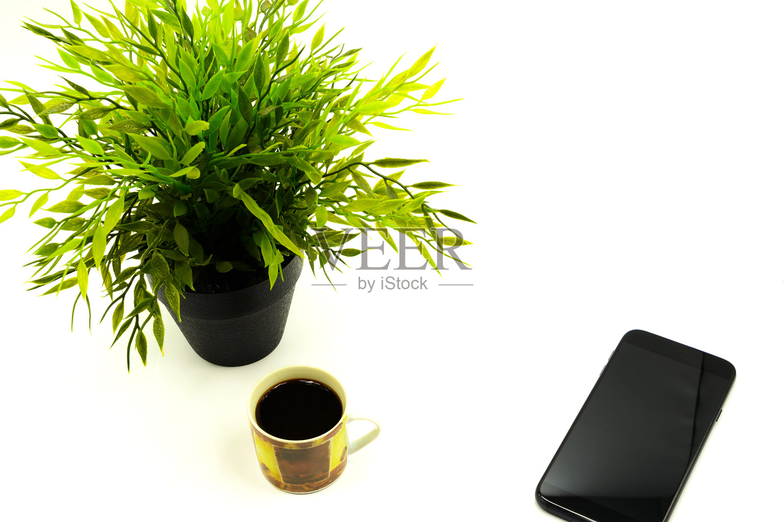 花盆里的人造绿花,咖啡杯里的一杯咖啡照片摄影图片