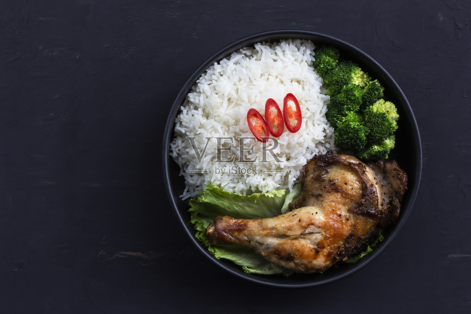 健康食品烤鸡有米饭和西兰花蔬菜在碗黑木桌子上。照片摄影图片