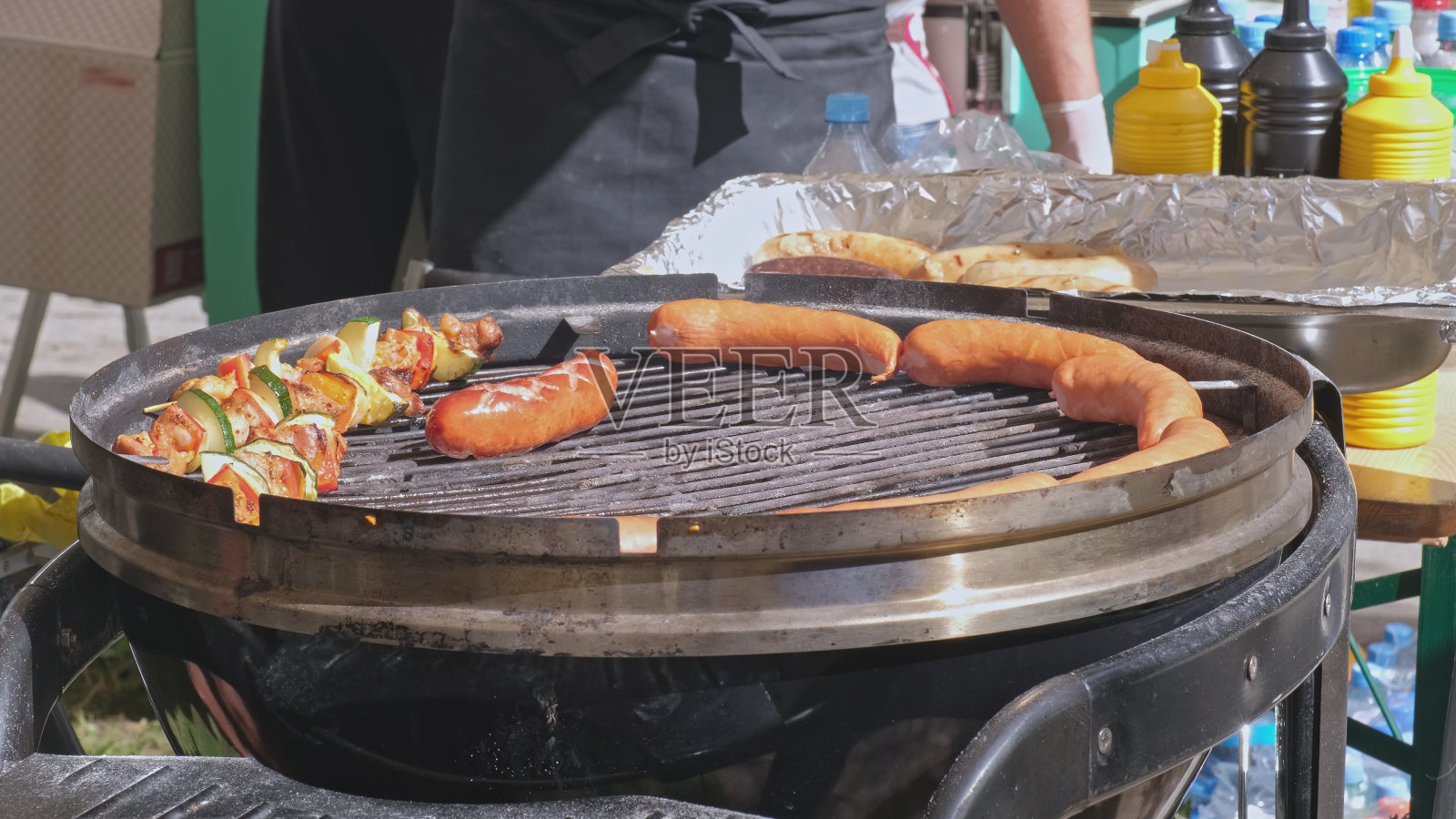 户外社区野餐食品摊不健康快餐帐篷,有烤香肠和烤肉串照片摄影图片
