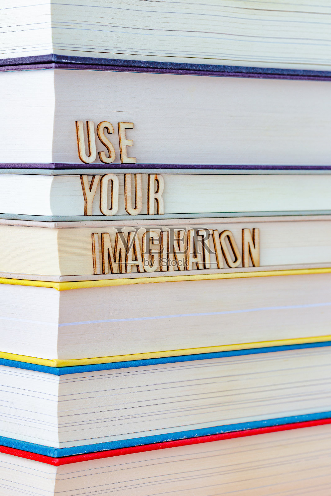 一堆书,上面的字母拼成“发挥你的想象力”照片摄影图片