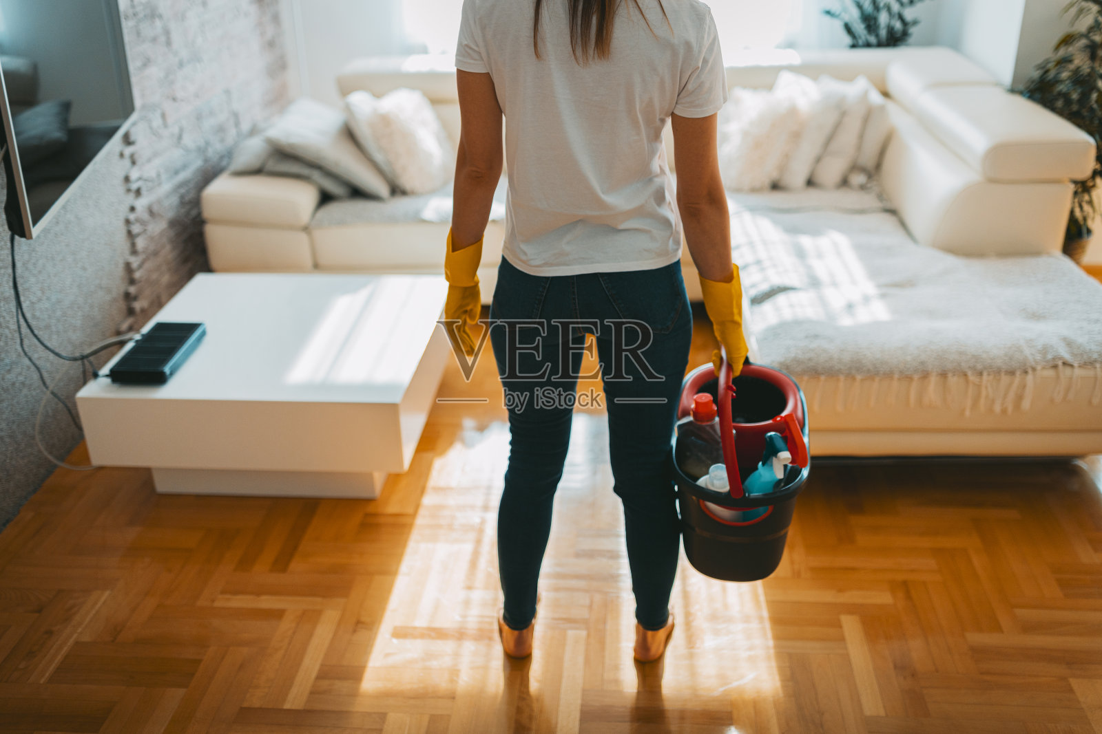 一个女人提着一桶清洁产品照片摄影图片