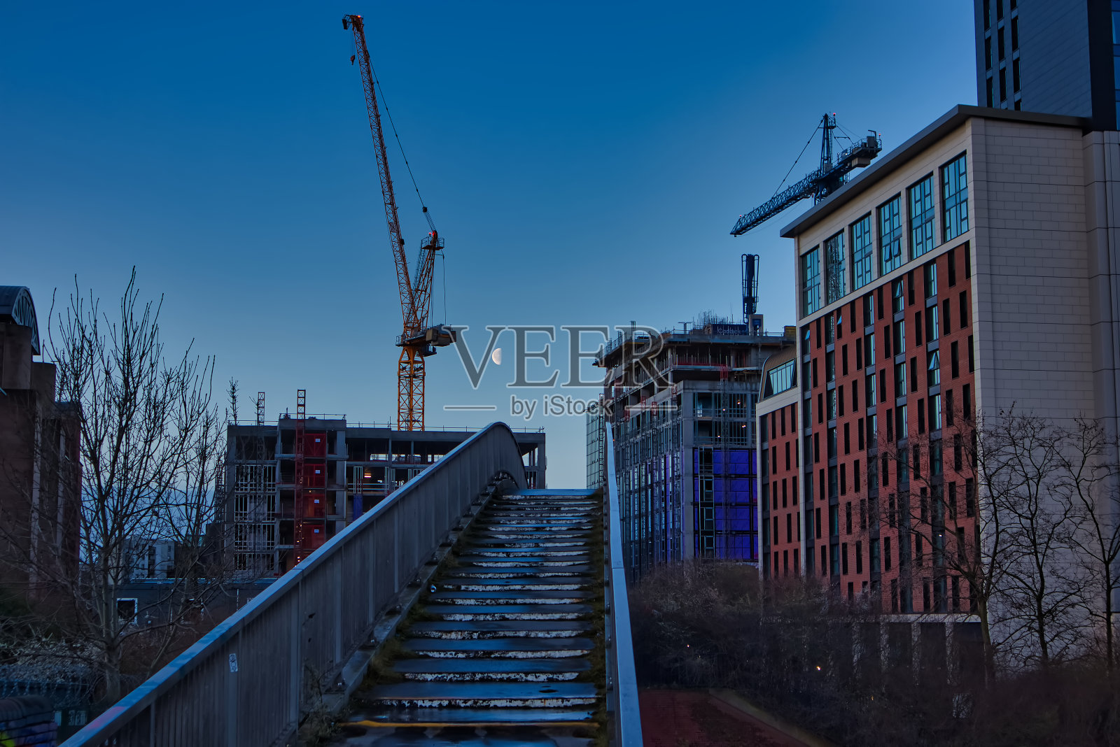 月亮在黄昏的天空中,在城市的建筑工地,利兹,西约克郡,英格兰,英国照片摄影图片