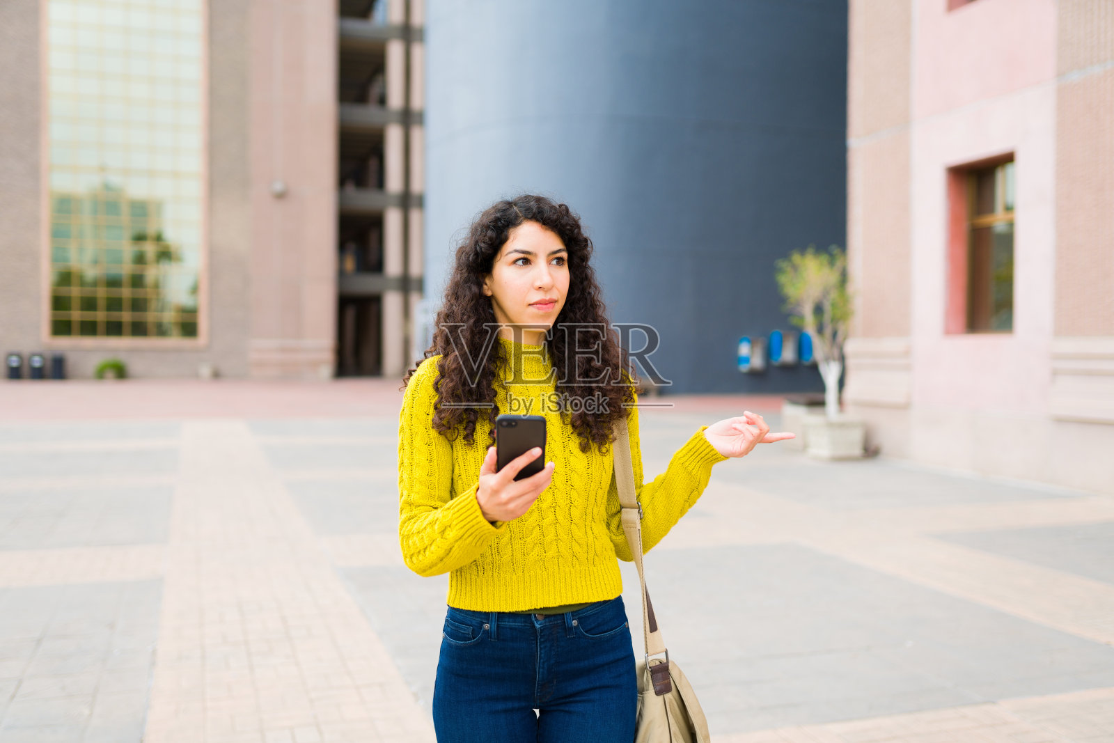 迷路的女人在城市里走的时候用手机和在线地图照片摄影图片