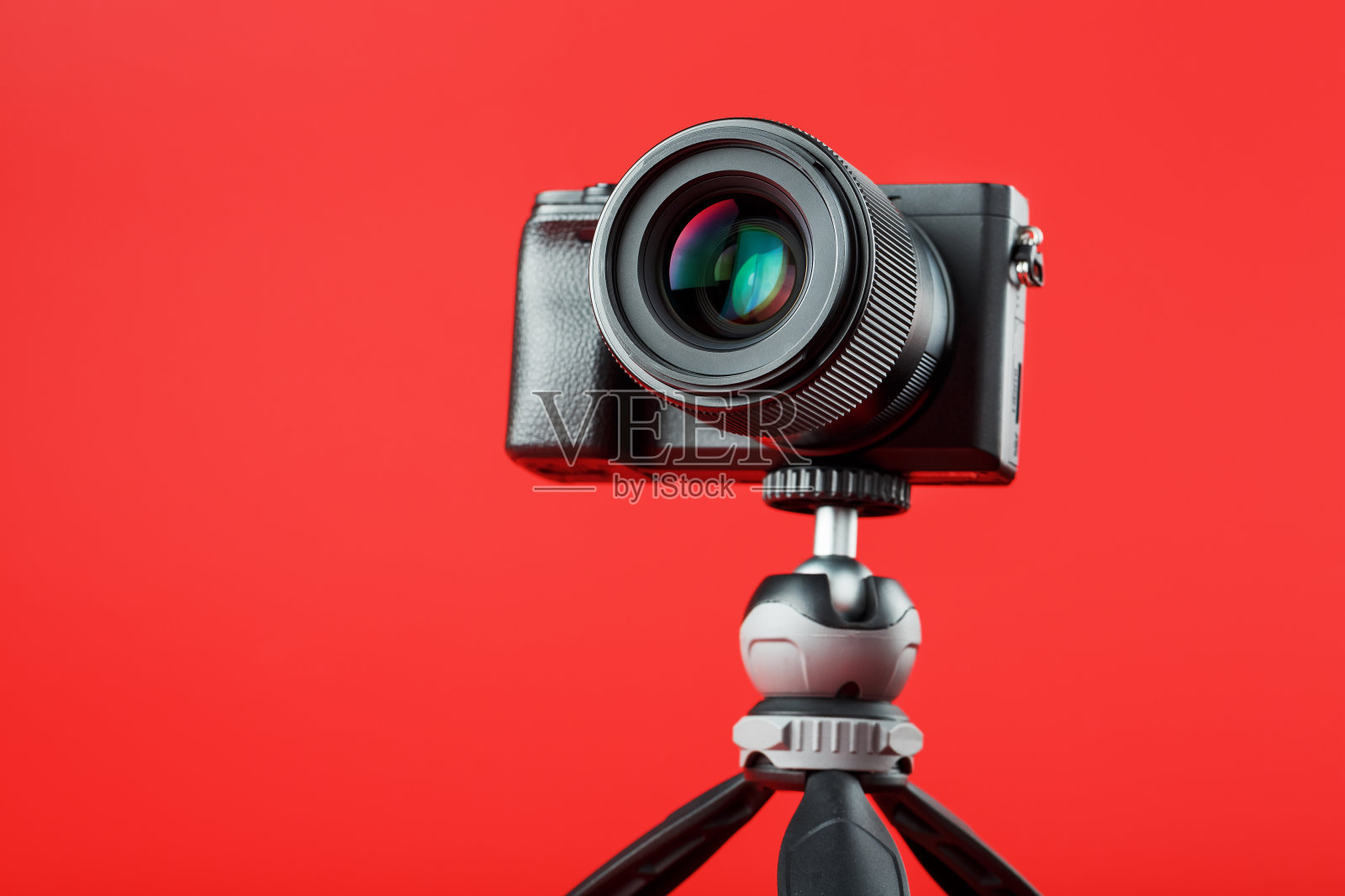 专业相机放在三脚架上,红色背景。为你的博客、报告文学记录视频和照片照片摄影图片