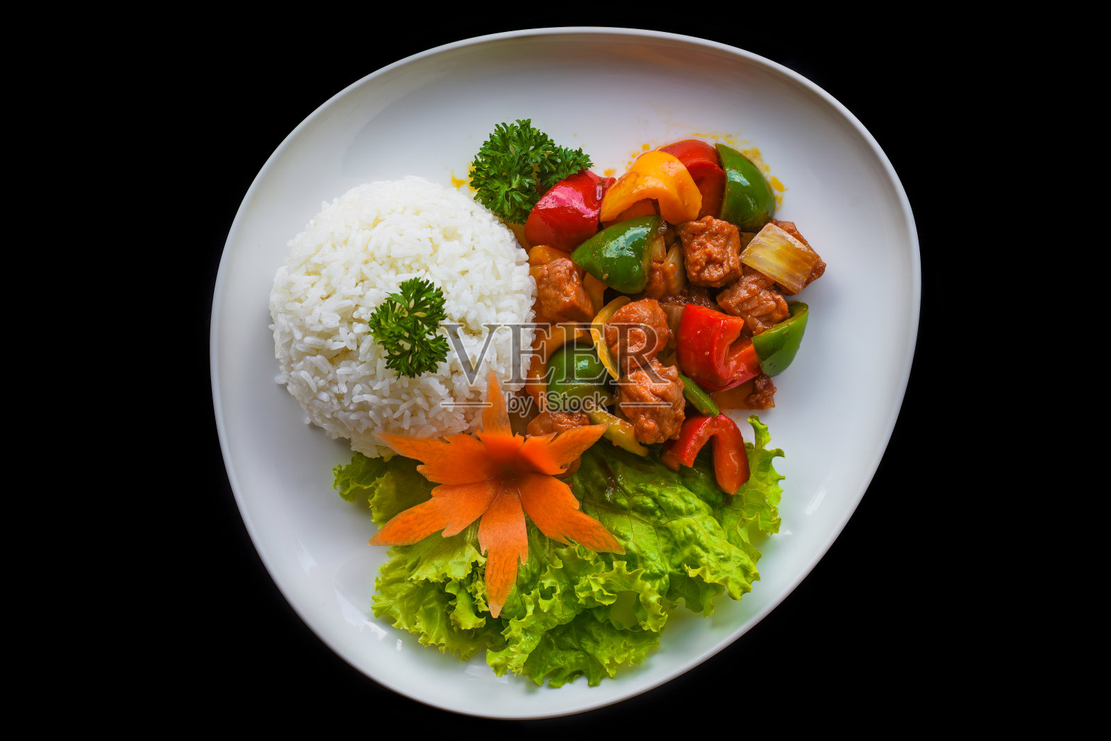 青菜炖牛肉和米饭放在蓝色盘子上,黑色背景俯视图照片摄影图片