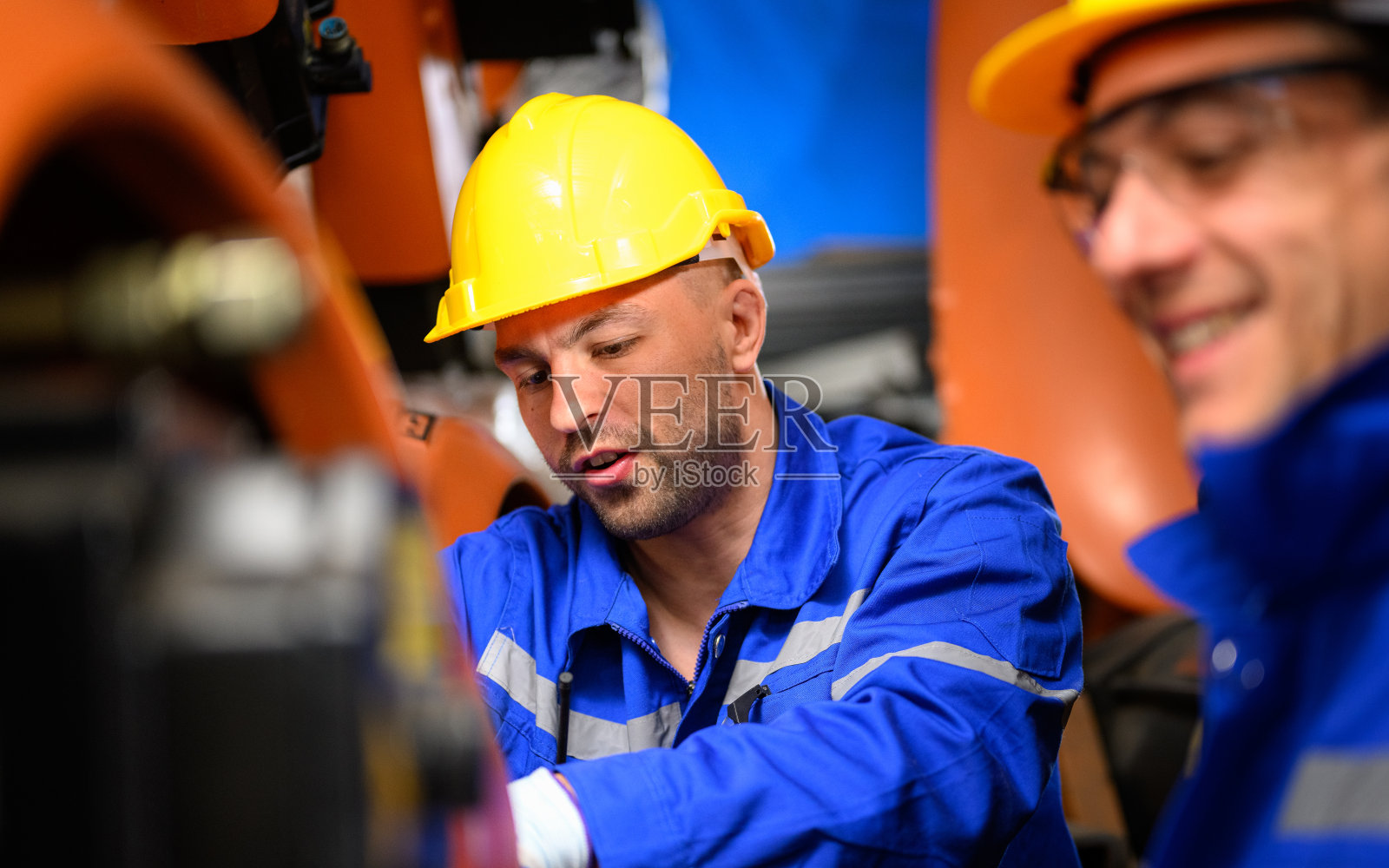 工业工厂机器机械臂的专业维修工人照片摄影图片