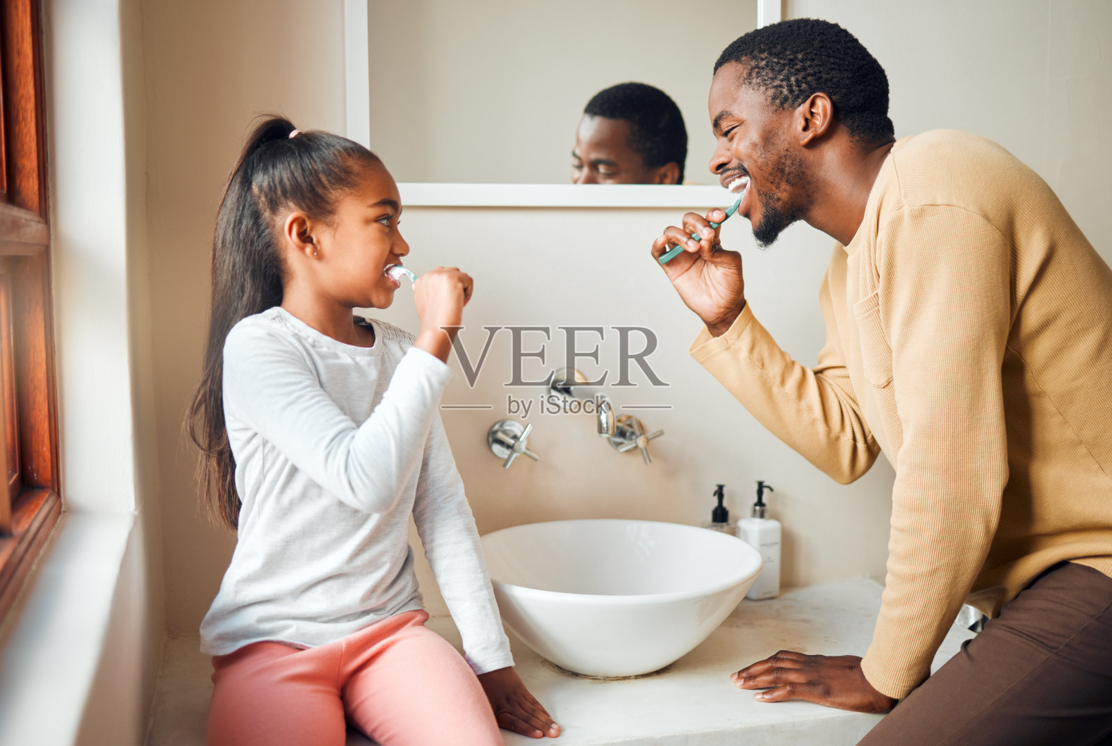 刷牙,牙齿健康,父亲和女儿在浴室里保持卫生,打扮和亲密。口腔护理,女孩和父母,人们和清洁,在家里玩得开心,嬉闹和微笑照片摄影图片