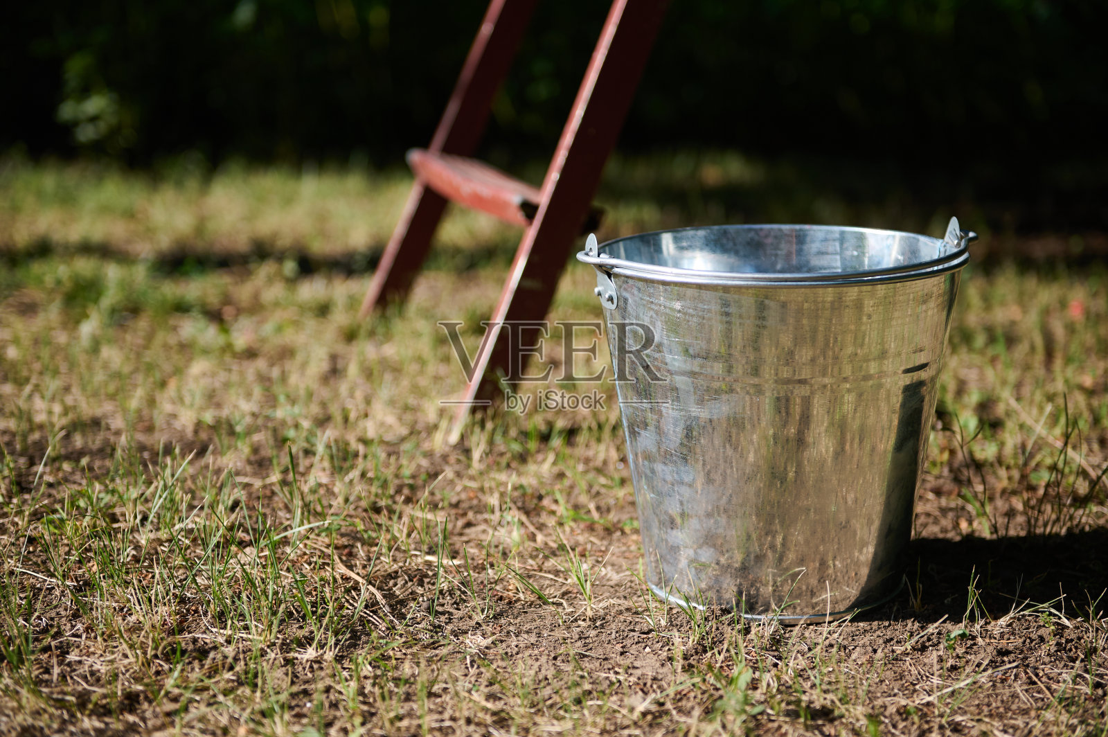 静物与金属镀锌桶在草地附近的旧楼梯在花园在农村照片摄影图片