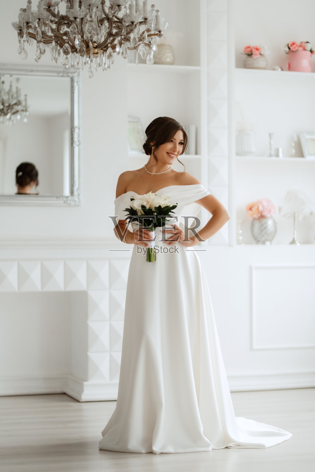 深色头发的新娘在明亮的工作室里穿着紧身婚纱照片摄影图片