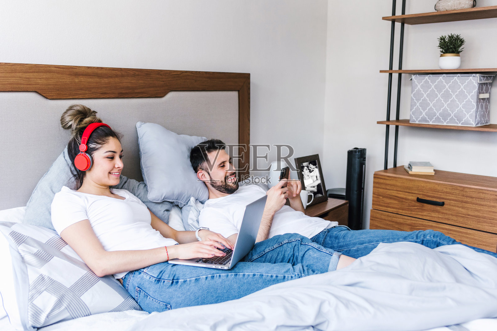 拉丁夫妇在床上使用笔记本电脑或在墨西哥的家里,西班牙人照片摄影图片