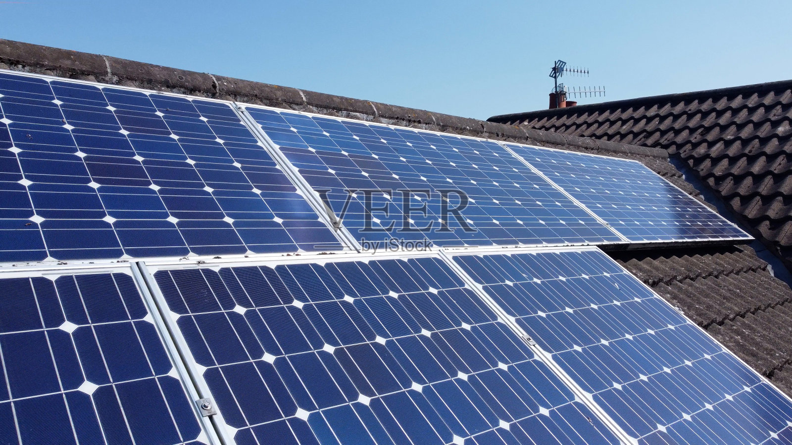 家庭屋顶上的太阳能电池板产生可再生电能照片摄影图片