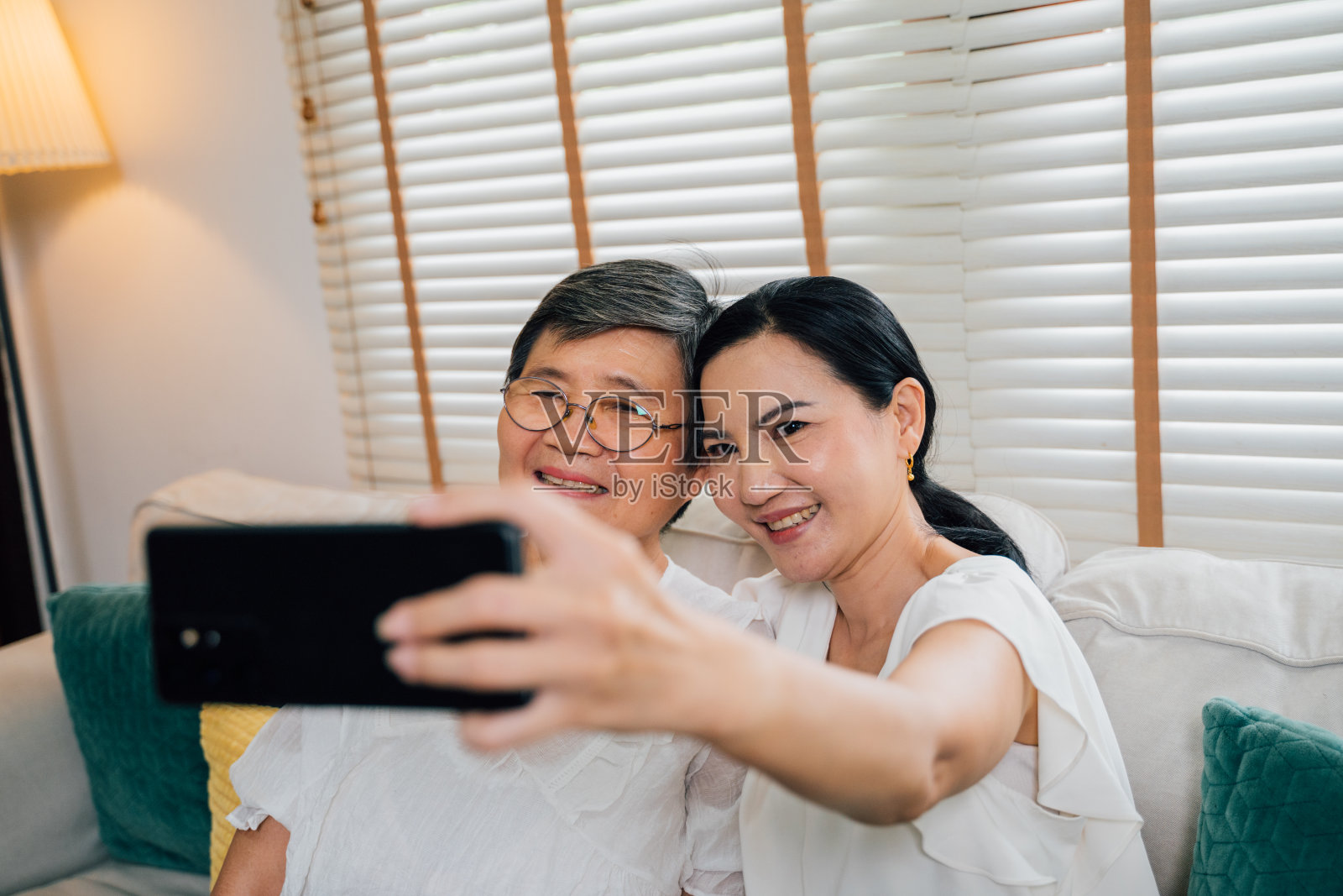 亚洲妈妈和女儿在沙发上自拍照片摄影图片