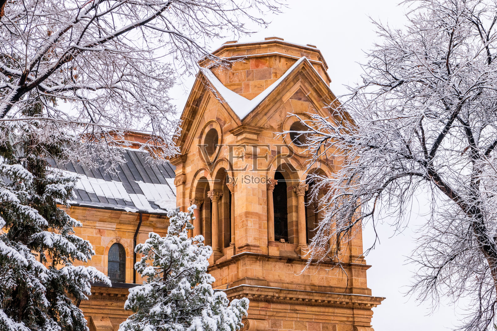 圣达菲的雪景,教堂钟楼和白雪覆盖的树木照片摄影图片