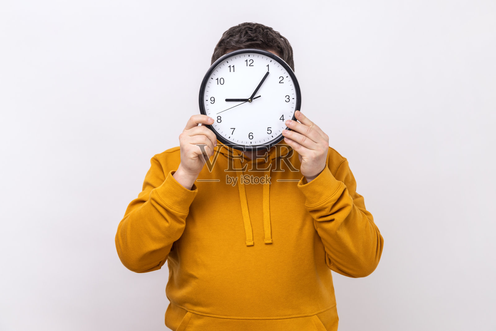 一个不知名的男人躲在大钟后面,时间管理,提醒截止日期。照片摄影图片