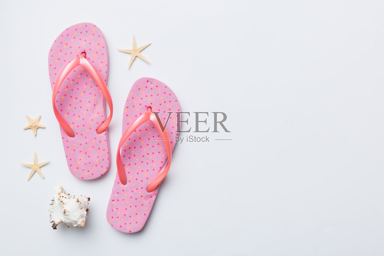 平面布局组成与人字拖和贝壳的彩色背景。文本顶视图的空间照片摄影图片