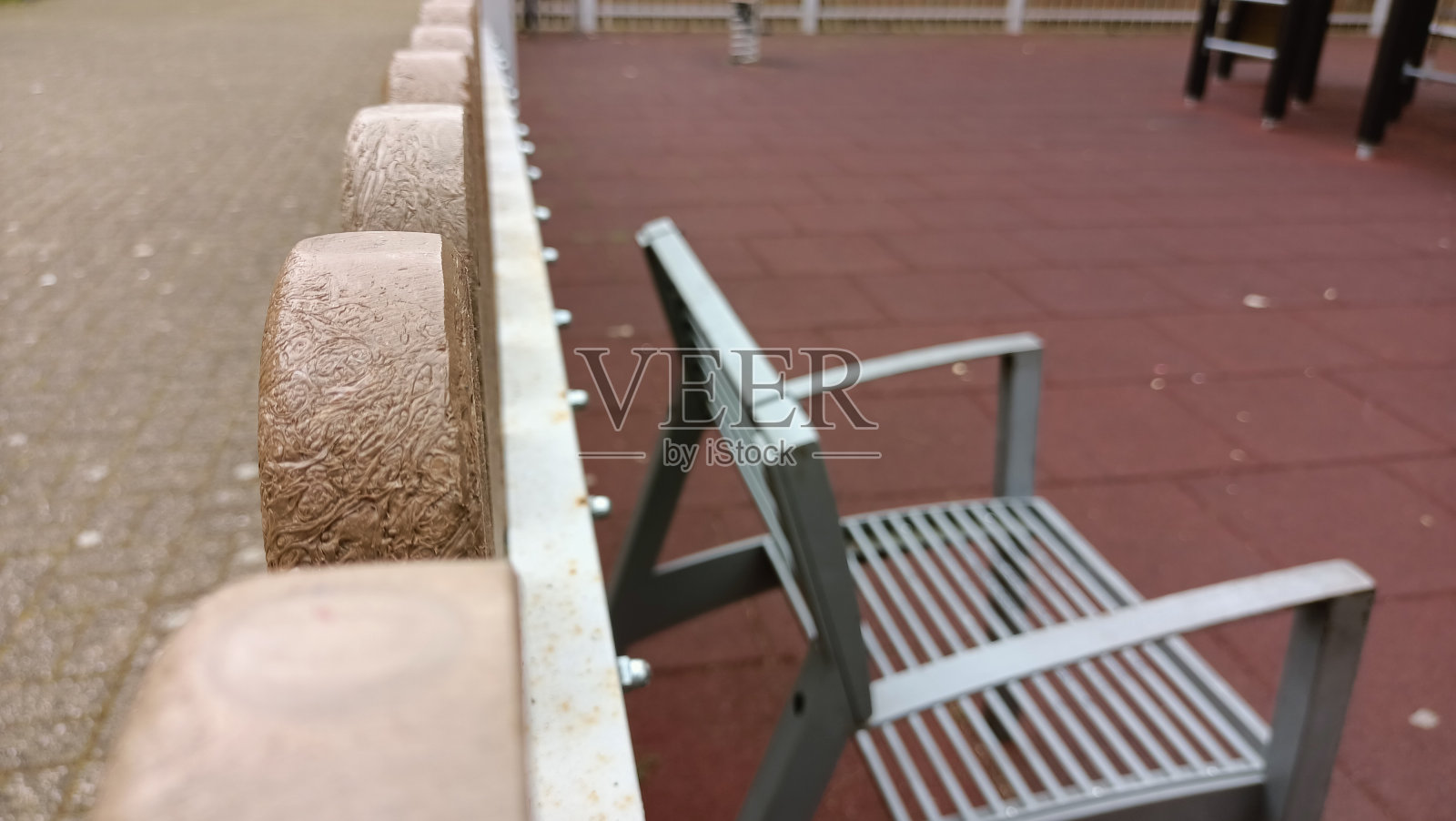 操场上塑料栅栏附近的铁凳照片摄影图片