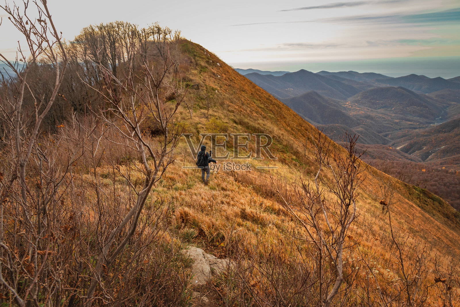 一个年轻人在山顶上享受大自然。照片摄影图片