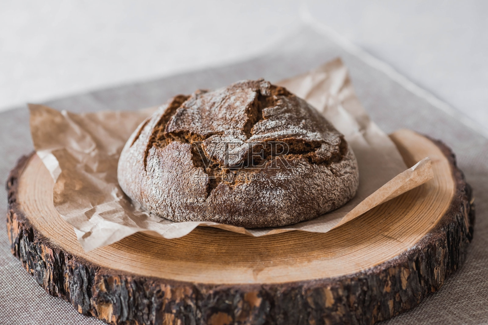 新鲜美味的面包特写。刚烤好的酸面包,金黄色的面包皮放在木板上。面包店里有美味的面包。糖果产品。照片摄影图片
