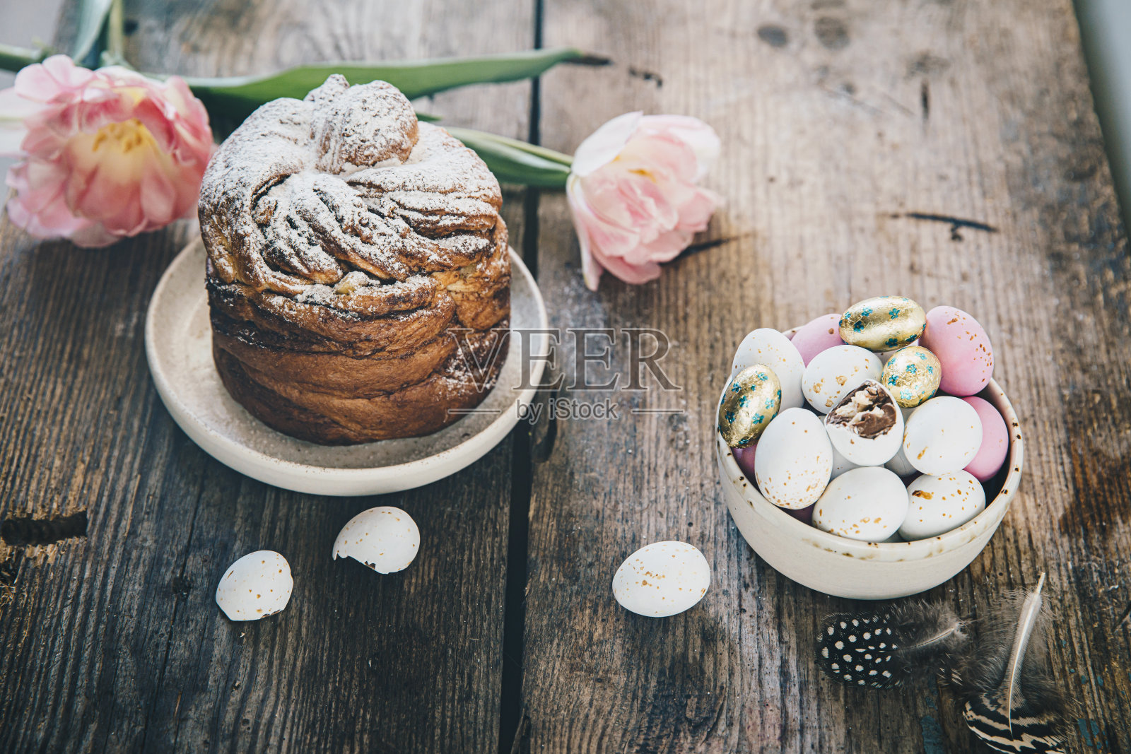 质朴的复活节桌子,有巧克力蛋、复活节面包和郁金香。照片摄影图片