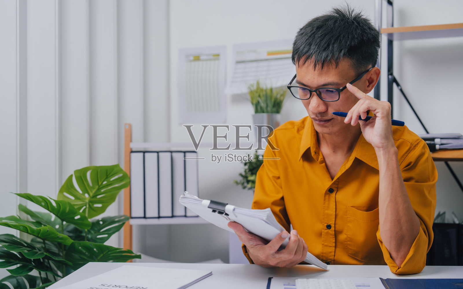 年轻认真的亚洲人簿记员做簿记企业家小企业主会计与资产负债表,所得税申报单和当地企业的预算。照片摄影图片