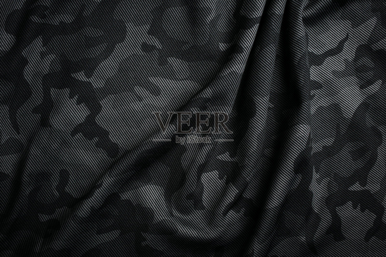 迷彩图案。时髦的深灰色迷彩面料。军事上的纹理。黑暗的背景。照片摄影图片