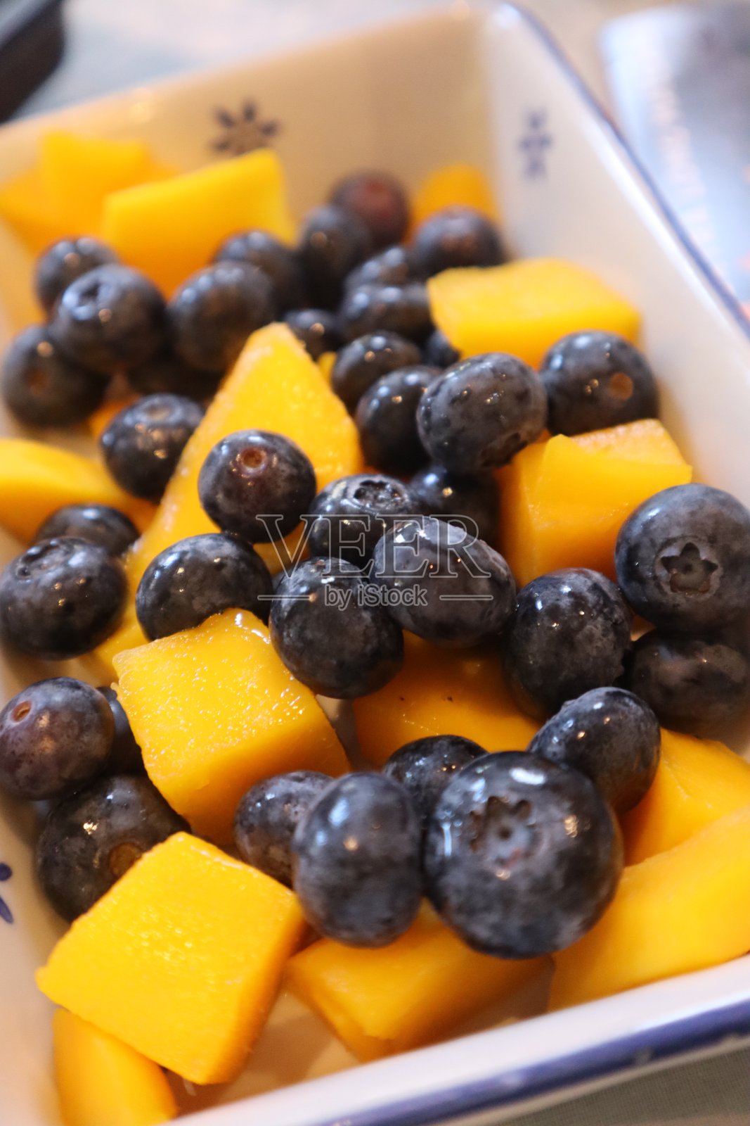 蓝莓和芒果紧紧地放在水果沙拉碗里照片摄影图片