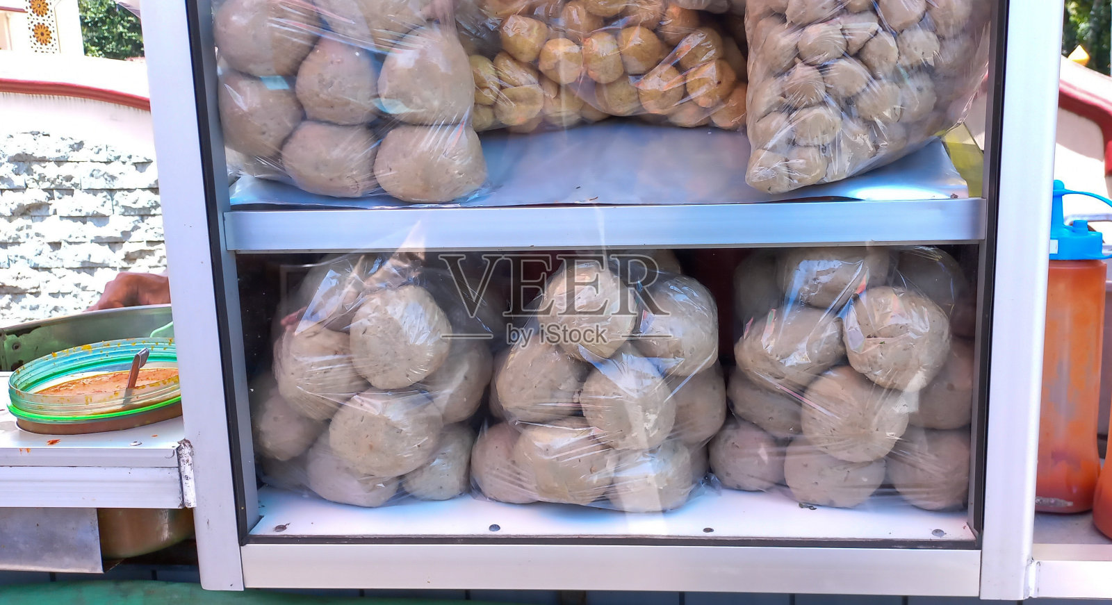 肉丸和酱汁装在玻璃柜里,准备出售照片摄影图片