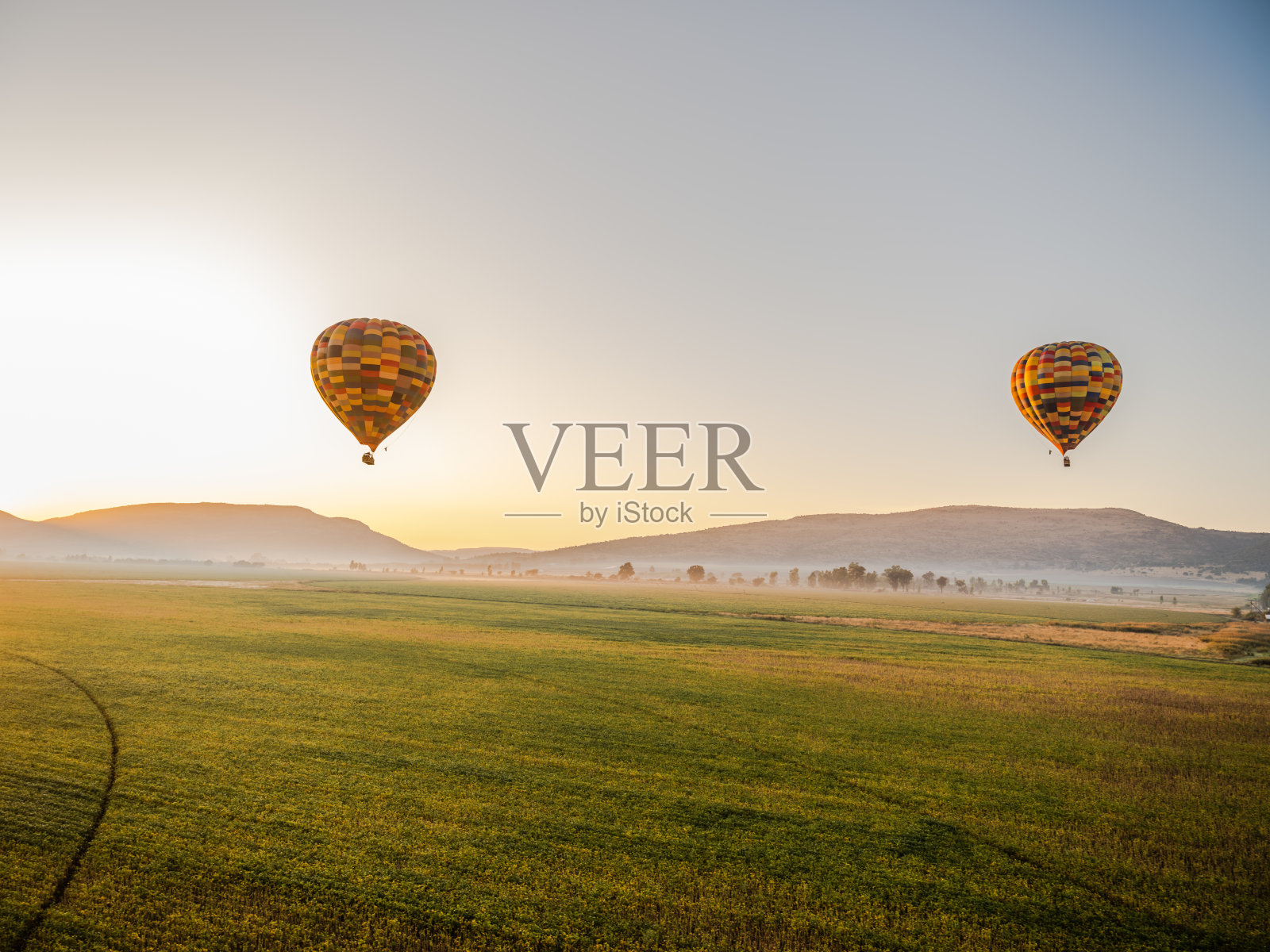 南非豪登省马格利斯堡,日出时分,五颜六色的热气球飞过农田上空照片摄影图片