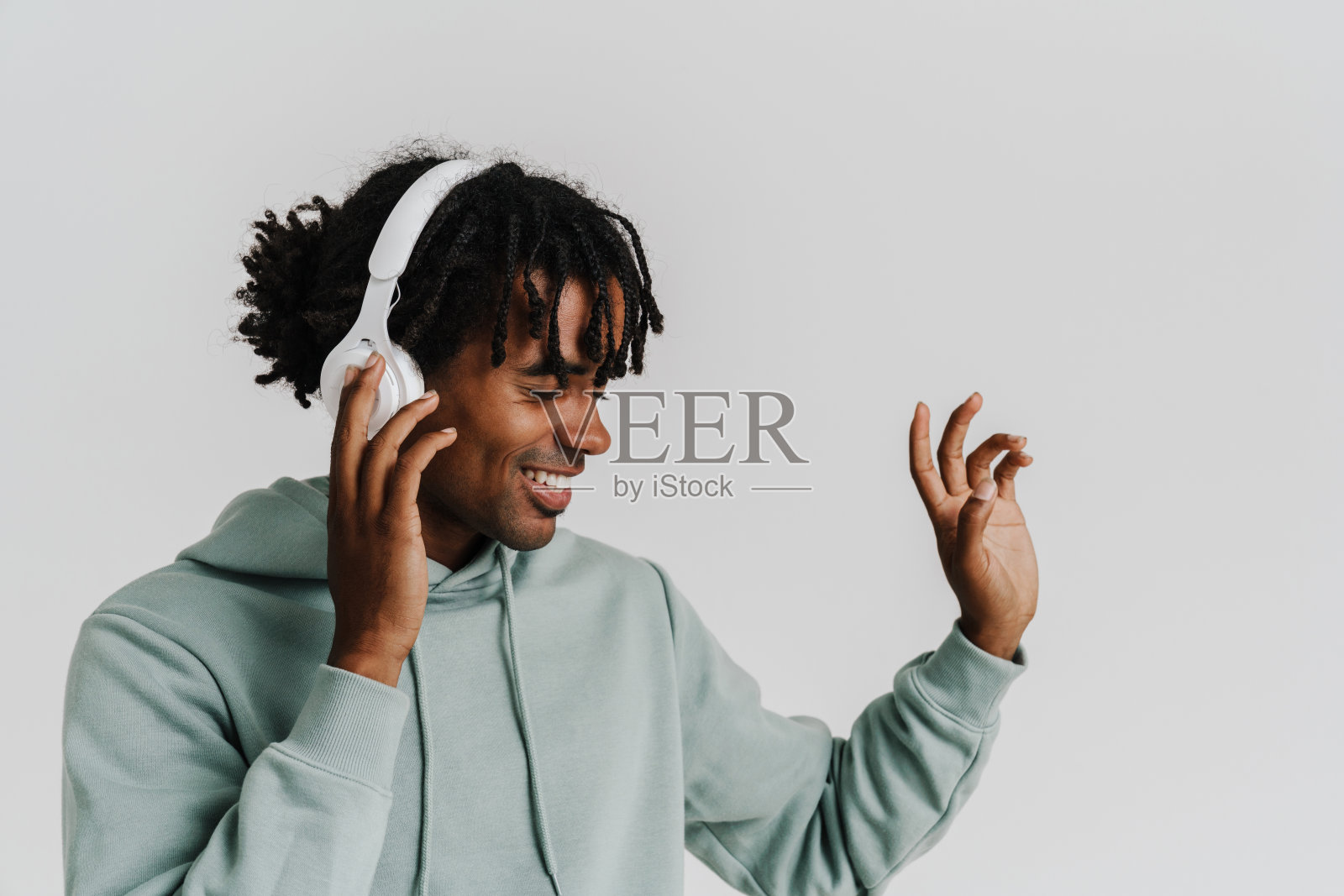 兴奋的年轻爆炸男子听音乐与耳机和手势隔离照片摄影图片