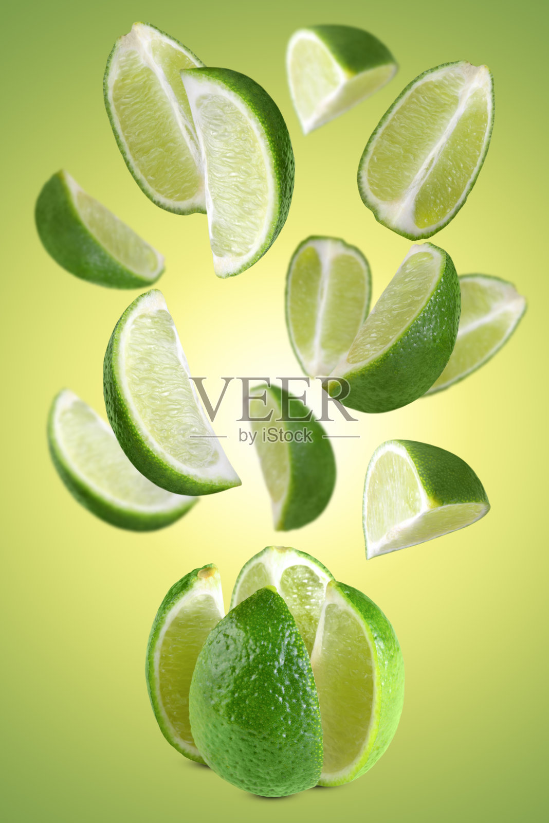 悬浮的青柠片在绿色的背景。照片摄影图片