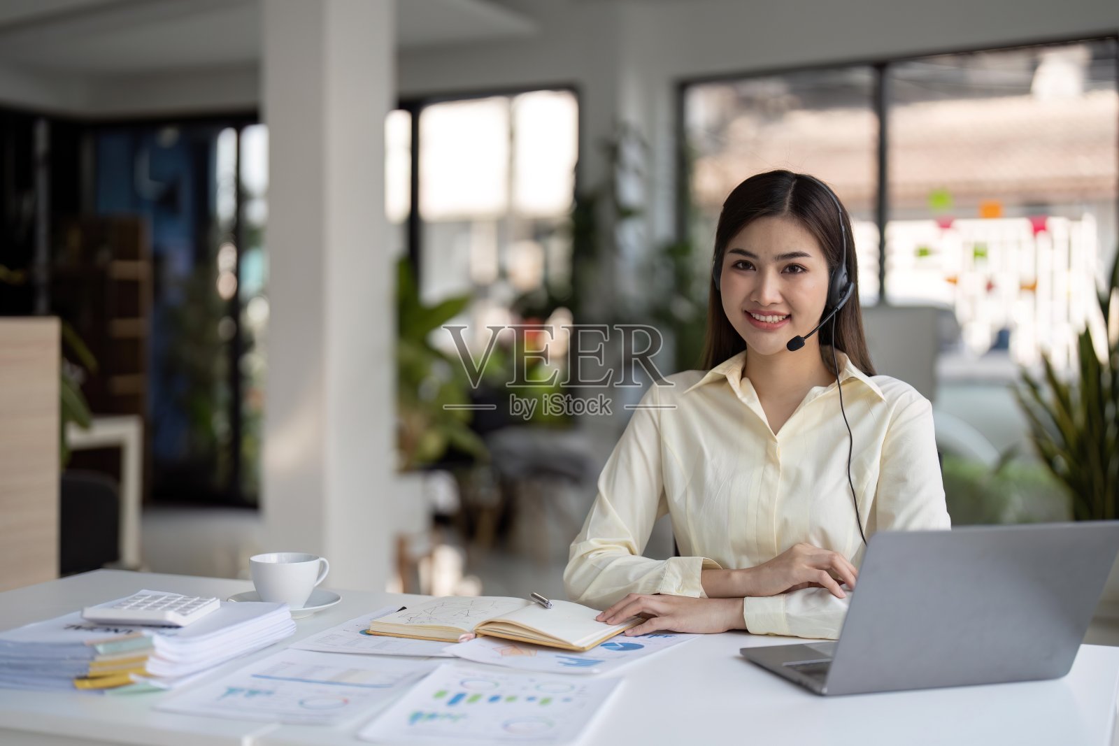 工作场所中快乐微笑的女性客服电话接线员照片摄影图片