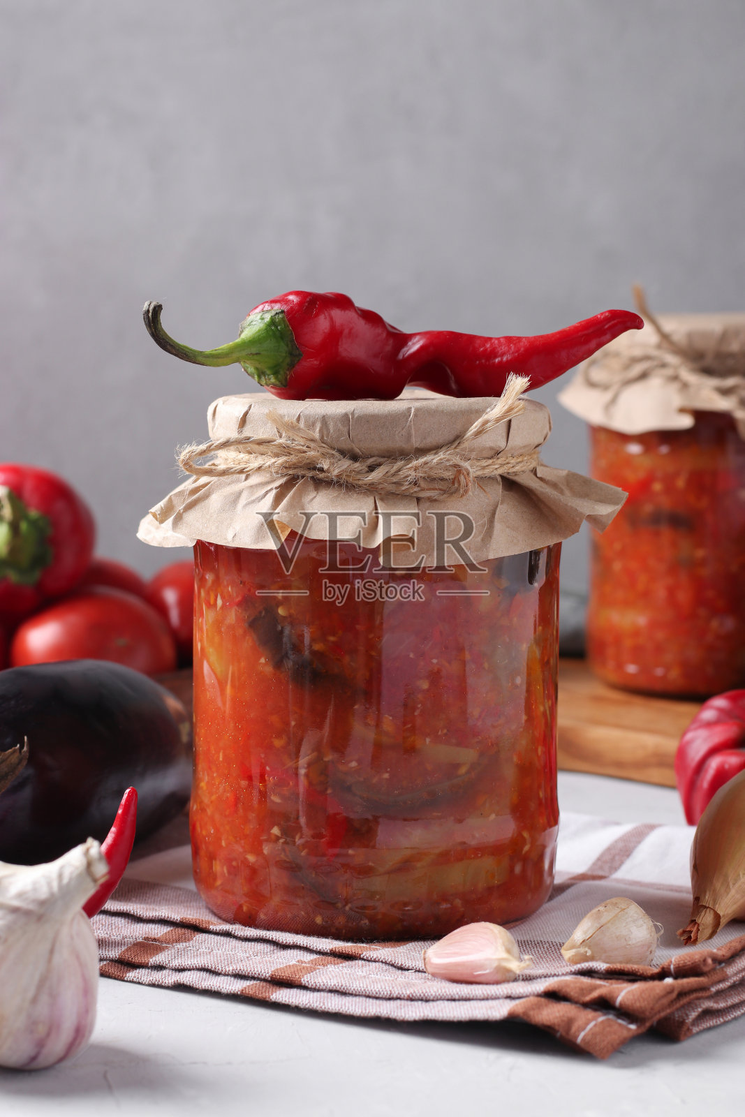 蔬菜沙拉,茄子,胡萝卜,辣椒,洋葱和西红柿,玻璃罐子,灰色背景照片摄影图片