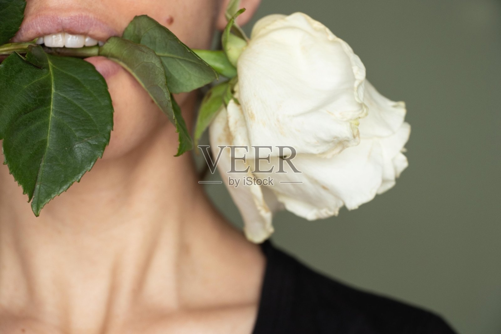 近距离的肖像,一个年轻的女孩与枯萎的白玫瑰。照片摄影图片