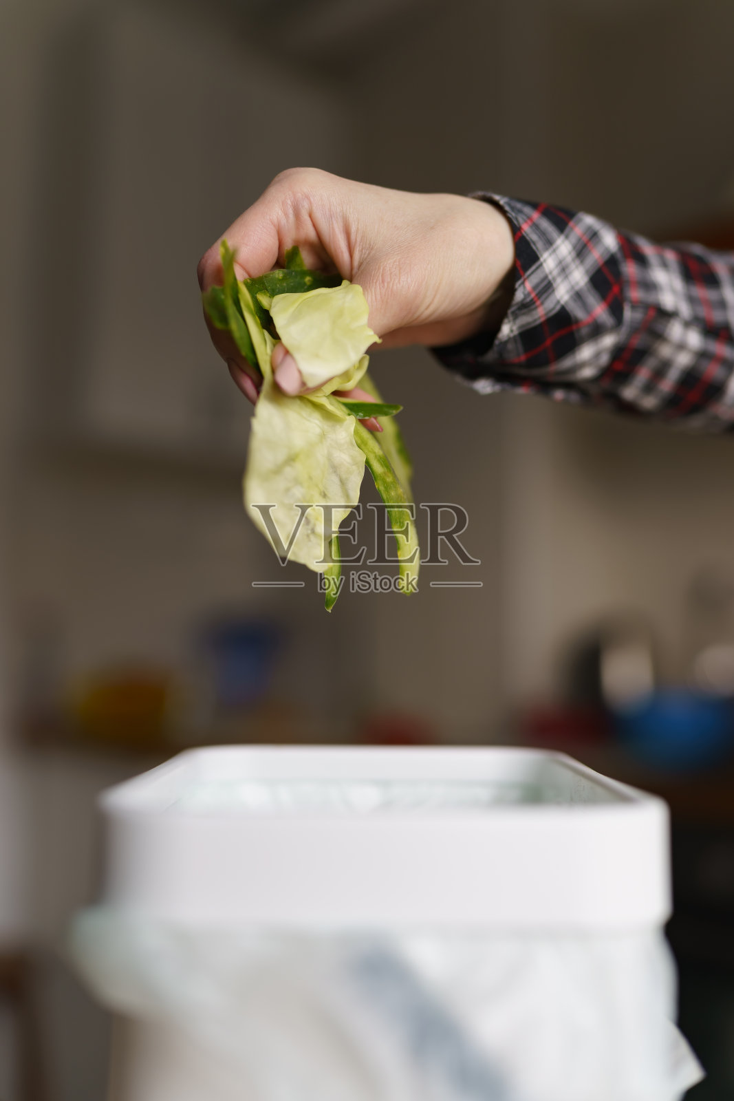 一名妇女在博卡什垃圾桶里回收有机食品垃圾。女性在家里用可生物降解的垃圾制作堆肥照片摄影图片
