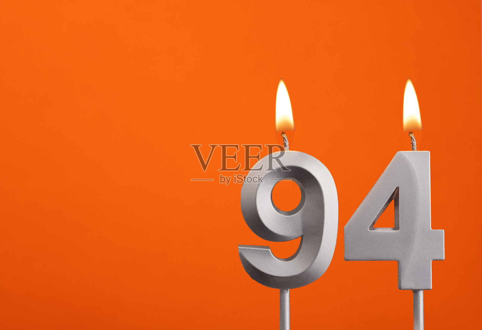 第94号-橙色背景的银周年纪念蜡烛照片摄影图片