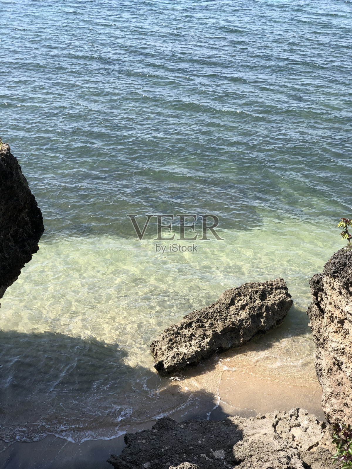 海滩,清澈的海水和周围的岩石照片摄影图片