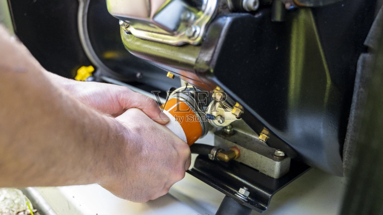 机械检查和更换立式发电机机油滤清器照片摄影图片