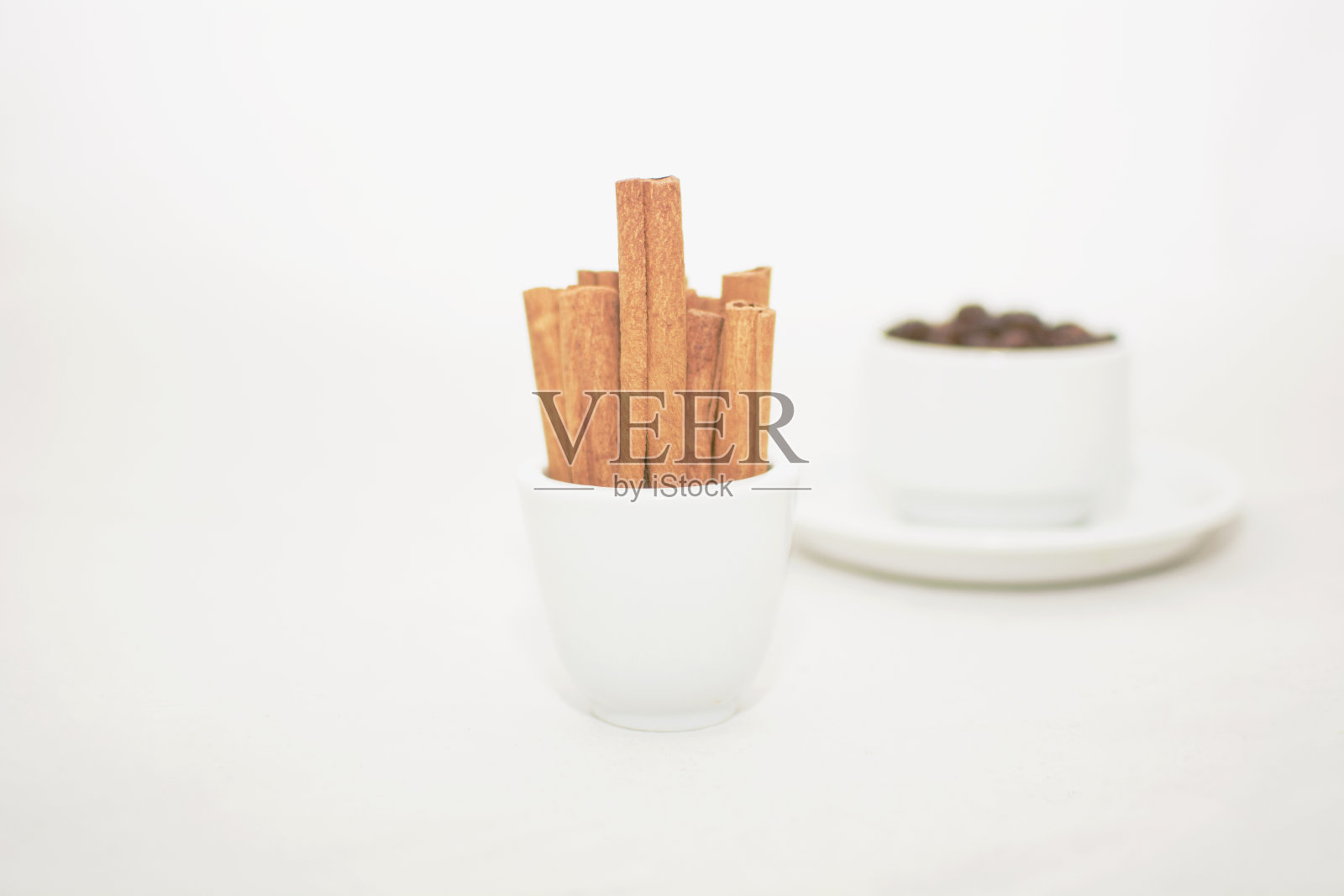 一个白色的杯子,在蓝绿色的美丽背景上有咖啡豆,还有一盏火照片摄影图片