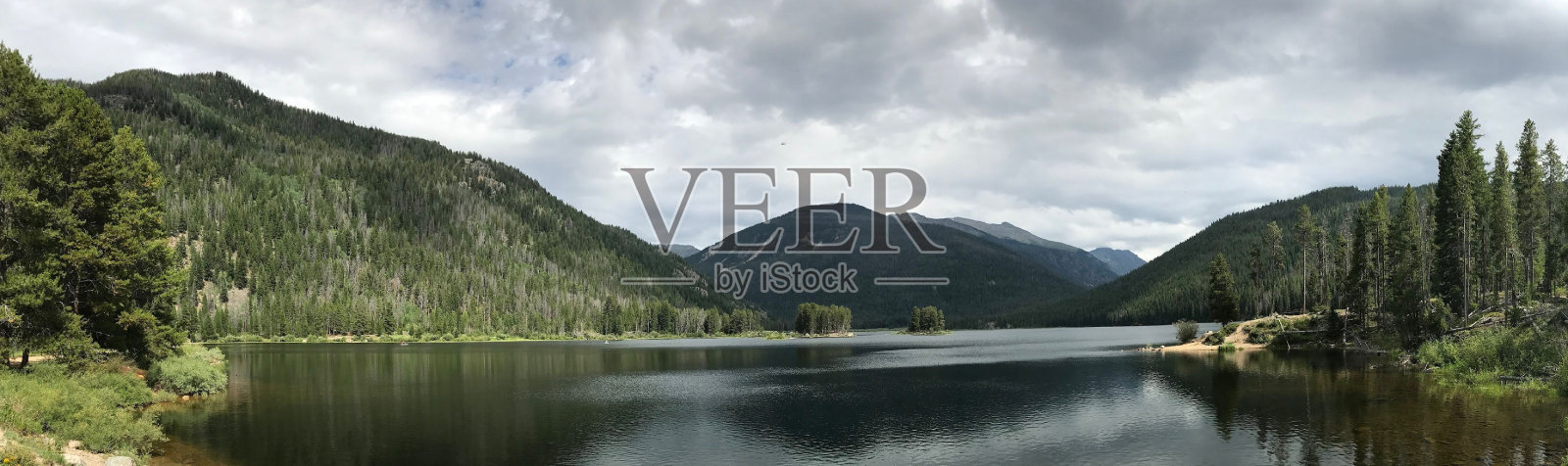 令人惊叹的景观,一个宁静的湖泊,周围是郁郁葱葱的森林和山脉。照片摄影图片