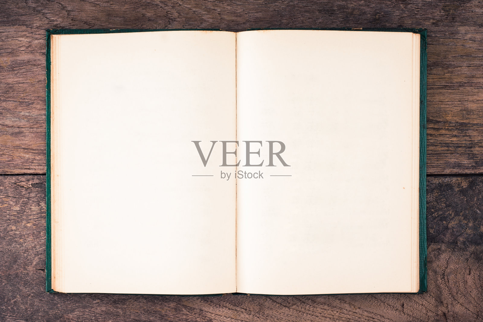 打开空白页的复古墨绿色精装书在旧木桌照片摄影图片
