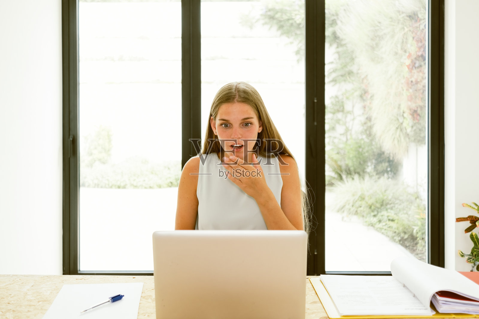 惊讶的年轻女士坐在笔记本电脑前照片摄影图片