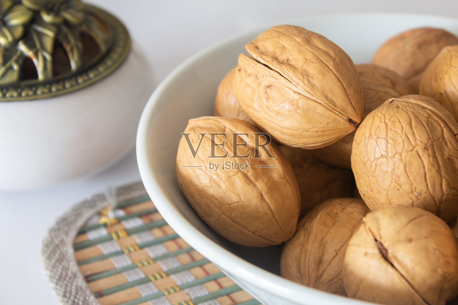 整个核桃放在白色的碗里。带壳核桃的健康零食照片摄影图片