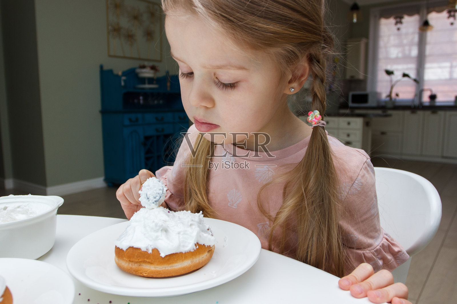 可爱的小女孩用甜美的颜色装饰蛋糕,烹饪的概念照片摄影图片