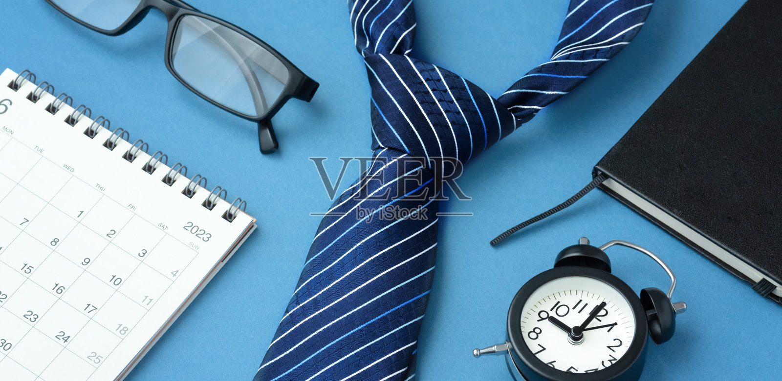领带与日历,时钟,笔记本蓝色背景,商务约会和会议概念照片摄影图片